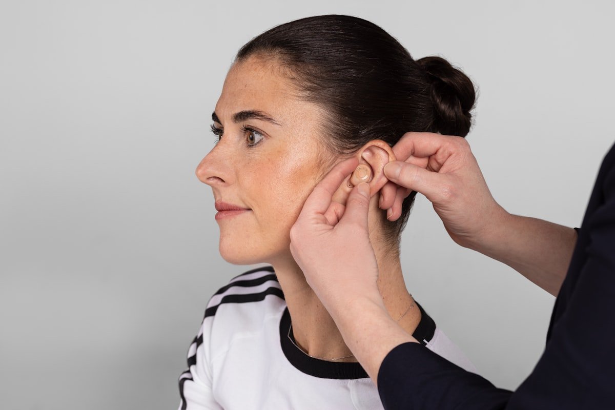 Molde auricular sendo colocado na orelha